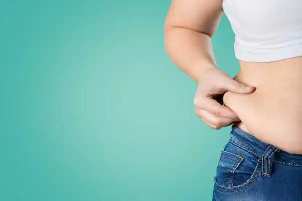 Image of woman pinching her love handles to show weight gain Dunstable